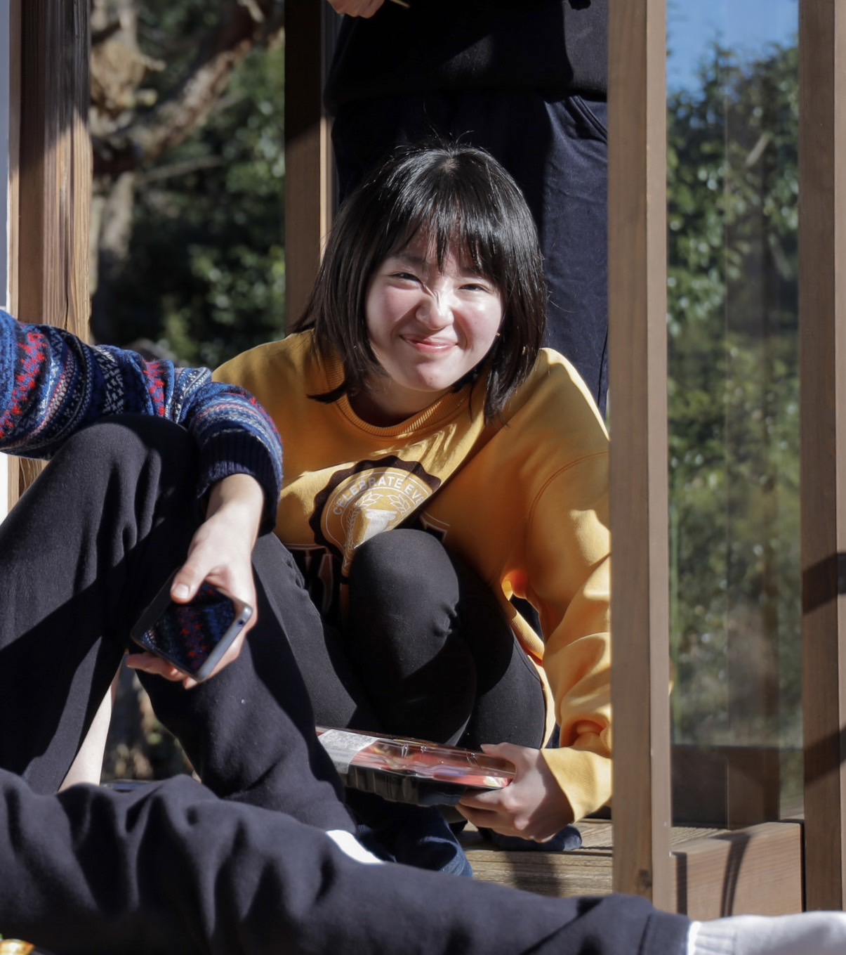 班員に囲まれながら笑顔を見せる『たねび』坪内さくら監督（画面中央）